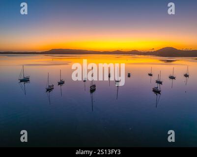 Alba sull'acqua di Brisbane, con cieli prevalentemente limpidi e una piccola nuvola luminosa alta intorno al Couche Park, Koolewong sulla costa centrale, NSW, Australi Foto Stock