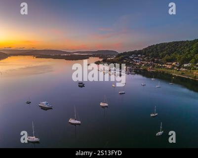 Alba sull'acqua di Brisbane, con cieli prevalentemente limpidi e una piccola nuvola luminosa alta intorno al Couche Park, Koolewong sulla costa centrale, NSW, Australi Foto Stock