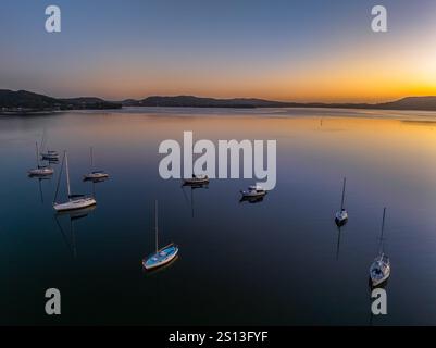 Alba sull'acqua di Brisbane, con cieli prevalentemente limpidi e una piccola nuvola luminosa alta intorno al Couche Park, Koolewong sulla costa centrale, NSW, Australi Foto Stock