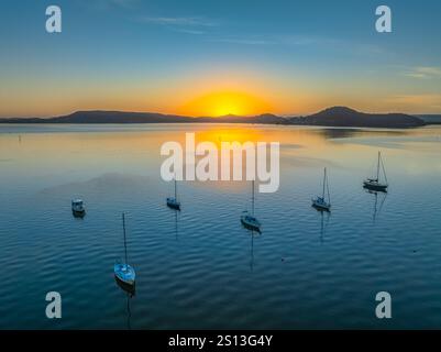 Alba sull'acqua di Brisbane, con cieli prevalentemente limpidi e una piccola nuvola luminosa alta intorno al Couche Park, Koolewong sulla costa centrale, NSW, Australi Foto Stock