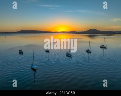 Alba sull'acqua di Brisbane, con cieli prevalentemente limpidi e una piccola nuvola luminosa alta intorno al Couche Park, Koolewong sulla costa centrale, NSW, Australi Foto Stock