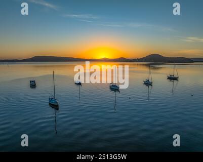 Alba sull'acqua di Brisbane, con cieli prevalentemente limpidi e una piccola nuvola luminosa alta intorno al Couche Park, Koolewong sulla costa centrale, NSW, Australi Foto Stock