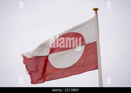 Una splendida rappresentazione della bandiera groenlandese con il suo iconico design rosso e bianco. Le forme semicircolari della bandiera simboleggiano il sole e il ghiaccio, ref Foto Stock