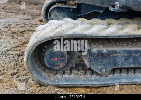Primo piano di cingoli continui in gomma su un escavatore. Foto Stock