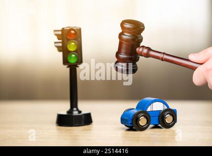 Gavel, macchinina blu giocattolo vicino a un semaforo sul tavolo. Informazioni sul traffico e sulle regole di guida. Incidente d'auto, guida ubriaca, tribunale, giustizia Foto Stock