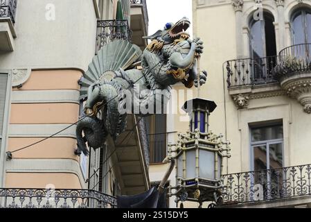 Barcellona, Catalogna, Spagna, Europa, fantastica statua del drago con lanterna sulla facciata di un edificio con balconi, Europa Foto Stock
