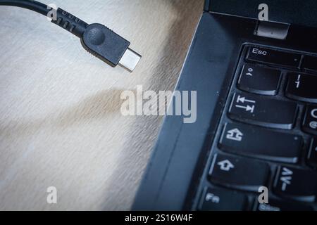 Foto concettuale di un cavo USB-C con tastiera per computer laptop Foto Stock