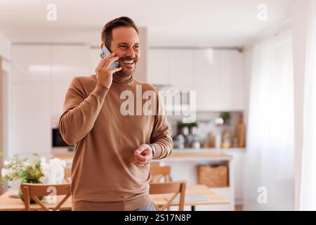 Ritratto di un uomo d'affari adulto di successo che parla al telefono mentre si trova in un ufficio domestico Foto Stock