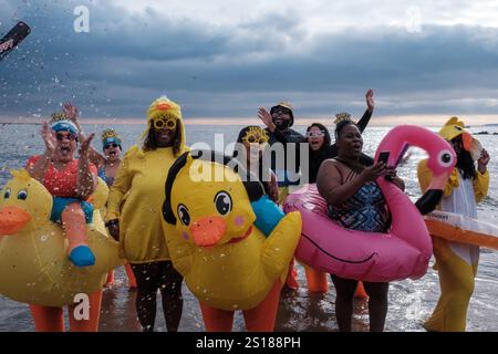 New York, Stati Uniti. 1 gennaio 2025. I partecipanti vestiti da anatre e un tifo di fenicottero mentre vengono fatti i coriandoli. I newyorkesi celebrano il nuovo anno con l'annuale Coney Island Polar Bear Plunge. L'evento raccoglie fondi per varie organizzazioni di beneficenza. (Foto di Syndi Pilar/SOPA Images/Sipa USA) credito: SIPA USA/Alamy Live News Foto Stock