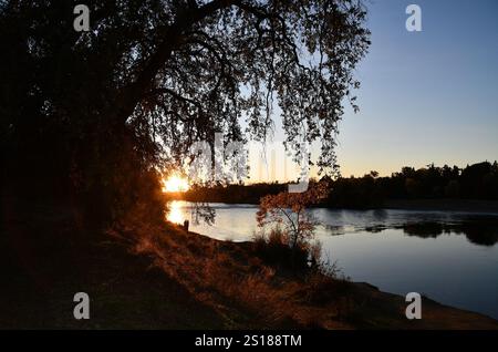 Una coppia gode della bellezza del fiume American, in mostra durante il tramonto l'11 novembre 2024. Il distretto di Sacramento del corpo degli ingegneri dell'esercito degli Stati Uniti sta lavorando per preservare la bellezza della zona, laddove possibile, e al contempo sta adottando misure per proteggere il pubblico dall'erosione e dalle inondazioni. Foto Stock