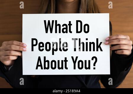 Cosa pensa la gente di te cosa pensa la gente di te donna con pagine bianche, lettere nere. Carattere, personalità, feedback. Banner A1989 071 Foto Stock
