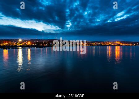 Panorama panoramico sul lungomare di notte con riflessi sull'acqua Foto Stock