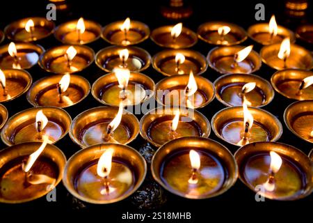 Lampade a olio in un tempio. Nel buddismo l'illuminazione di una candela o di una lampada ad olio rappresenta la luce della saggezza che illumina l'oscurità dell'ignoranza, in H Foto Stock