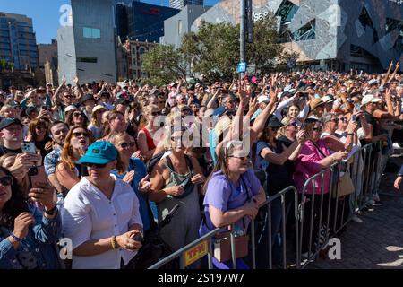 I fan tifosi si con entusiasmo mentre Robbie Williams sale sul palco per uno spettacolo pomeridiano a Melbourne, Australia. Robbie Williams, Rock Star, ha affascinato 8.000 fan alla Federation Square di Melbourne, riempiendo il locale fino alla sua massima capacità per un concerto gratuito che celebra il suo film Better Man. La soleggiata esibizione pomeridiana ha visto la folla cantare, ballare e applaudire mentre Robbie mostrava i suoi successi iconici. I fan hanno portato cartelli e sorrisi, creando un'atmosfera vivace e gioiosa. Questo evento indimenticabile ha sottolineato il legame di Robbie con il suo pubblico e la passione per la musica di Melbourne. Foto Stock