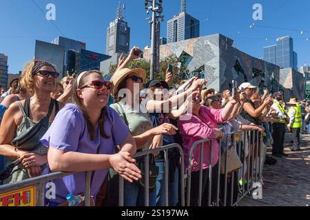 I fan tifosi si con entusiasmo mentre Robbie Williams sale sul palco per uno spettacolo pomeridiano a Melbourne, Australia. Robbie Williams, Rock Star, ha affascinato 8.000 fan alla Federation Square di Melbourne, riempiendo il locale fino alla sua massima capacità per un concerto gratuito che celebra il suo film Better Man. La soleggiata esibizione pomeridiana ha visto la folla cantare, ballare e applaudire mentre Robbie mostrava i suoi successi iconici. I fan hanno portato cartelli e sorrisi, creando un'atmosfera vivace e gioiosa. Questo evento indimenticabile ha sottolineato il legame di Robbie con il suo pubblico e la passione per la musica di Melbourne. Foto Stock