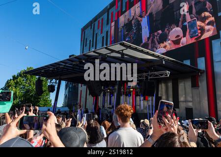 I fan tifosi si con entusiasmo mentre Robbie Williams sale sul palco per uno spettacolo pomeridiano a Melbourne, Australia. Robbie Williams, Rock Star, ha affascinato 8.000 fan alla Federation Square di Melbourne, riempiendo il locale fino alla sua massima capacità per un concerto gratuito che celebra il suo film Better Man. La soleggiata esibizione pomeridiana ha visto la folla cantare, ballare e applaudire mentre Robbie mostrava i suoi successi iconici. I fan hanno portato cartelli e sorrisi, creando un'atmosfera vivace e gioiosa. Questo evento indimenticabile ha sottolineato il legame di Robbie con il suo pubblico e la passione per la musica di Melbourne. Foto Stock