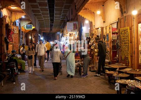 persone che camminano attraverso il suq semmarine di notte a marrakech, marocco Foto Stock