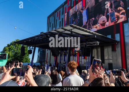 I fan tifosi si con entusiasmo mentre Robbie Williams sale sul palco per uno spettacolo pomeridiano a Melbourne, Australia. Robbie Williams, Rock Star, ha affascinato 8.000 fan alla Federation Square di Melbourne, riempiendo il locale fino alla sua massima capacità per un concerto gratuito che celebra il suo film Better Man. La soleggiata esibizione pomeridiana ha visto la folla cantare, ballare e applaudire mentre Robbie mostrava i suoi successi iconici. I fan hanno portato cartelli e sorrisi, creando un'atmosfera vivace e gioiosa. Questo evento indimenticabile ha sottolineato il legame di Robbie con il suo pubblico e la passione per la musica di Melbourne. (Foto di Foto Stock