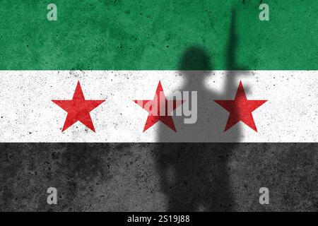 Nuova bandiera siriana dipinta sul muro di cemento con un soldato Foto Stock