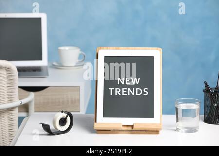 Nuove tendenze. Tablet moderno e cancelleria su scrivania bianca Foto Stock