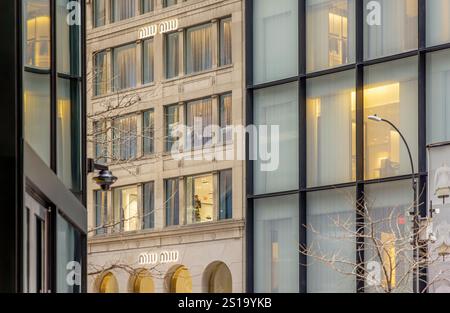 una donna che lavora in una finestra al secondo piano sulla 57esima strada est, new york Foto Stock