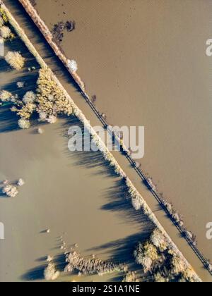 Vista aerea a volo d'uccello di una strada rurale allagata e dei campi circostanti vicino alla Fairburn Ings Nature Reserve, con acque alluvionali che coprono terreni bassi a seguito di lunghe piogge nel West Yorkshire, Inghilterra. Foto Stock