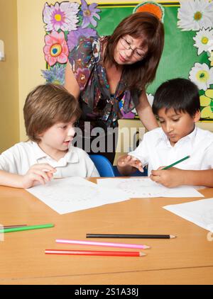 Scuola elementare: Consigli per l'insegnamento. Un paio di bambini della scuola elementare che si concentrano sul lavoro affidato loro dal loro insegnante in classe. Foto Stock