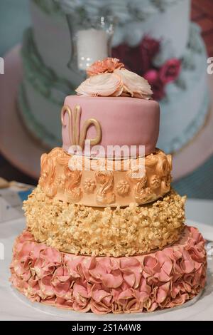 Torta nuziale con glassa rosa e fiori sopra Foto Stock