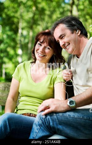 La vita inizia a 40 anni. Un momento di relax mentre una coppia matura condivide le cuffie e il loro gusto per la musica. Foto Stock
