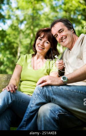 La vita inizia a 40 anni. Un momento di relax mentre una coppia matura condivide le cuffie e il loro gusto per la musica. Foto Stock