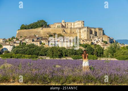 Francia, Drôme, Grignan, etichettato Les Plus Beaux Villages de France, campo di lavanda di fronte alla cappella romanica del XII secolo Saint-Vincent, il villaggio e il castello di Grignan il castello di Grignan, residenza della linea di Adhémar per sei secoli Foto Stock