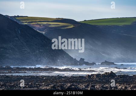 La nebbia marina si innalza dal surf mattutino a Widemouth Bay all'inizio di gennaio Foto Stock