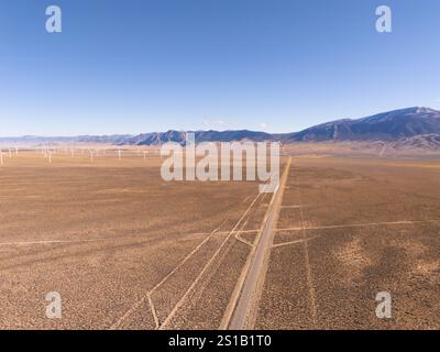Veduta aerea della U.S. Route 50, la strada più solitaria degli Stati Uniti, e di un parco di mulini a vento nel Nevada interno, deserto elevato e montagne innevate. Foto Stock