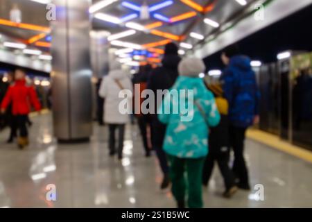 Un'immagine sfocata che cattura le persone che camminano in una trafficata stazione della metropolitana, mostrando i loro movimenti e interazioni in questo centro di trasporto urbano Foto Stock