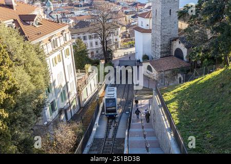 Lugano, Svizzera - 24 dicembre 2024: Una funicolare viaggia a fianco dei pedoni su una scala nella panoramica città di Lugano Foto Stock