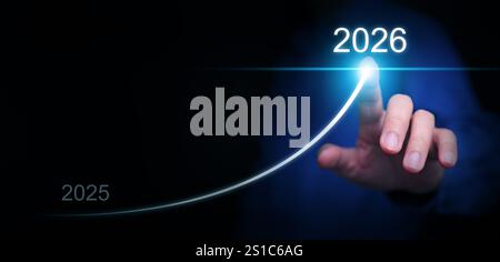 Felice anno nuovo. Un uomo d'affari disegna una linea in aumento, dal 2025 al 2026, che rappresenta la crescita mirata, il successo e il successo, per iniziare e accogliere con favore il Foto Stock