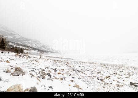Vista panoramica del lago Abraham ghiacciato e nebbioso in Alberta, Canada durante l'inverno, una popolare destinazione turistica invernale Foto Stock