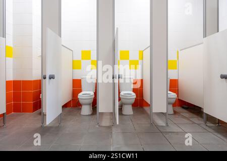 I moderni bagni interni presentano bancarelle pulite con pareti piastrellate vivaci e un design efficiente per la comodità dell'utente Foto Stock