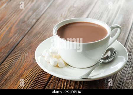 cacao in tazza bianca e marshmallow sul piattino sul tavolo Foto Stock