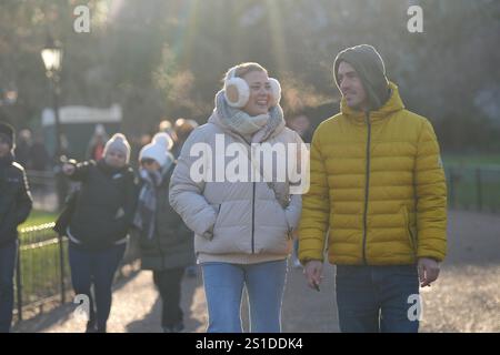 La gente affronta il freddo camminando attraverso St James's Park nel centro di Londra. L'Agenzia per la sicurezza sanitaria del Regno Unito (UKHSA) ha emesso avvisi di salute in caso di basse temperature per tutta l'Inghilterra prima di una settimana di basse temperature. Gli allarmi Amber sono stati emessi dalle 12:00 di giovedì fino all'8 gennaio, il che significa che è probabile un aumento dei decessi, in particolare tra coloro di età pari o superiore ai 65 anni o con condizioni di salute, ha detto l'UKHSA. Data foto: Venerdì 3 gennaio 2025. Foto Stock