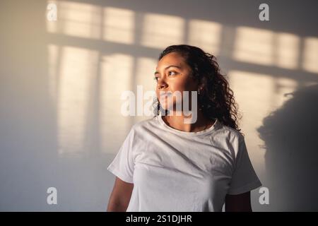 Giovane donna che si gode i raggi del sole in casa al tramonto Foto Stock