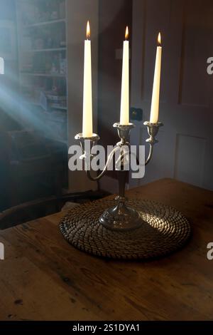 Fumare candele contro la luce solare in un candelabro a tre braccia. REGNO UNITO Foto Stock