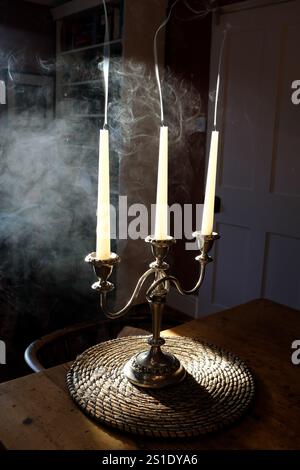 Fumare candele contro la luce solare in un candelabro a tre braccia. REGNO UNITO Foto Stock