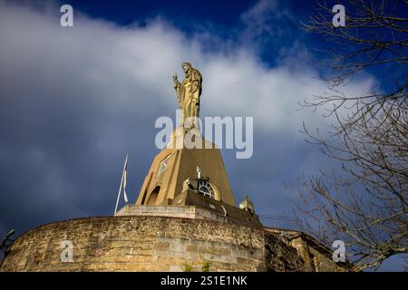 Vista ravvicinata della statua del Cristo de la Mota in cima al Monte Urgull con il cielo spettacolare a San Sebastián, Spagna. Monumenti religiosi e architettura. Alto Foto Stock