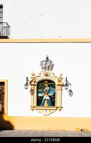 Retablo cerámico, Cristo de la Expiración y Virgen de las Aguas, obra de Antonio Morilla Galea de 1963. Fachada de la Capilla del Museo, Siviglia. Foto Stock