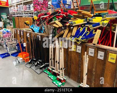 Kiev, Ucraina - 3 gennaio 2025: Un assortimento di utensili per la pulizia come spazzatrici e padelle ordinatamente disposti in un negozio. Gli elementi sono disponibili in V Foto Stock