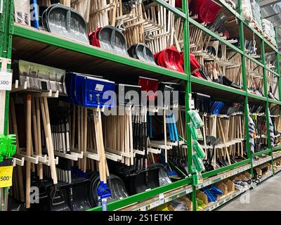 Kiev, Ucraina - 3 gennaio 2025: Un'ampia selezione di pale da neve colorate organizzate su scaffali in un corridoio di un negozio, con attrezzi per la neve invernale Foto Stock