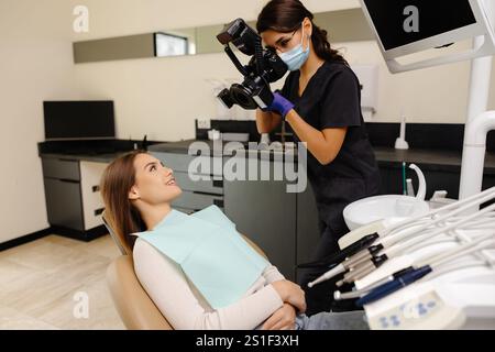 Dentista che fotografa con una fotocamera professionale il risultato del suo lavoro in clinica. Foto Stock