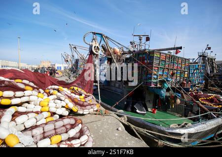 reti da pesca galleggianti che si stendono davanti alla moderna flotta di pescherecci del porto di essaouira, in marocco Foto Stock