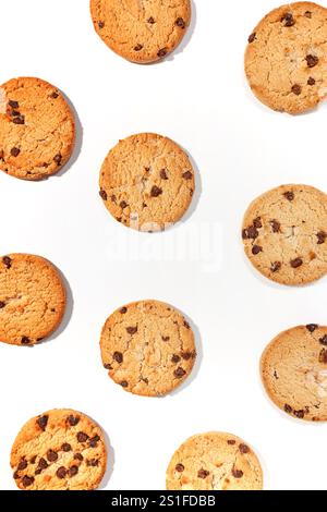Biscotti appena sfornati con gocce di cioccolato disposti su sfondo bianco Foto Stock